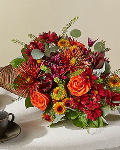 <p>Celebrate everything you’re thankful for with this iconic symbol of bounty and blessings resplendent with orange roses, bronze button pompons, red Leucadendron, and more.</p>